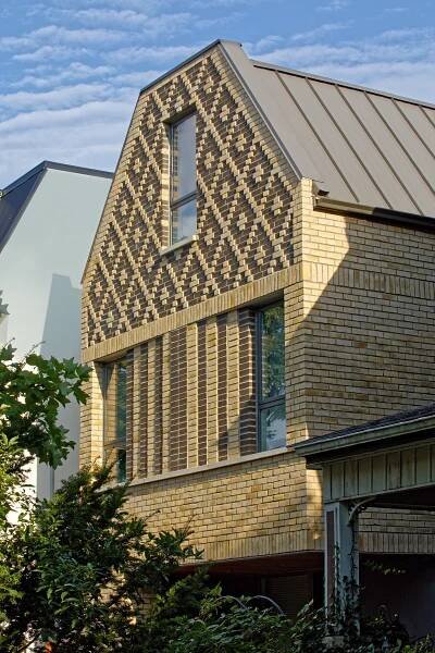 Detailní pohled na štít domu s ornamentálním cihelným vzorem.