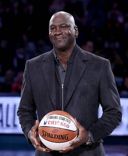 Michael Jordan holding a 2020 NBA All-Star game basketball.
