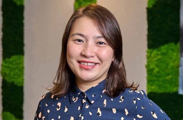 Ms Wendy Tan posing for a photo in an office setting.