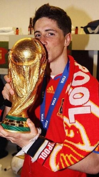 a young man kissing the world cup trophy