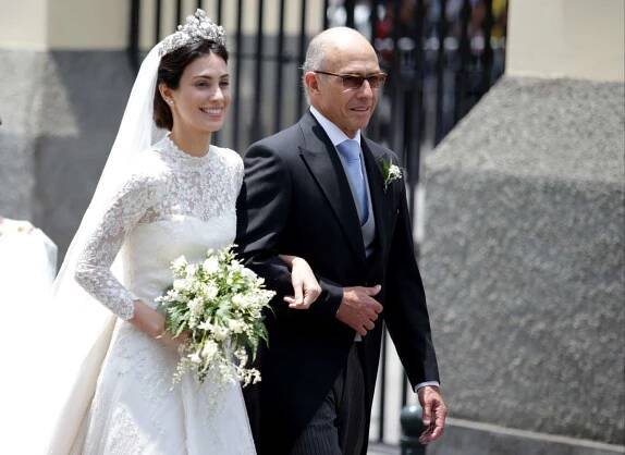 Alessandra de Osma carrying a white bouquet with father Felipe de Osma on her wedding day