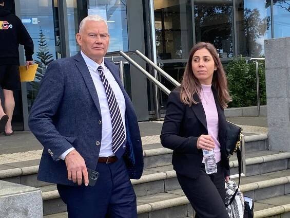 Coll MacRury walking down steps with woman next to him