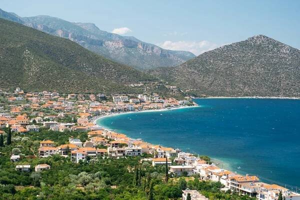 a bay with a town with red roofs and mountain tops at the background, Tyros in Peloponnese, Greece