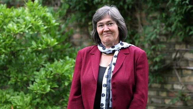 Clare Short standing in the garden at her home. She is wear a white and navy scarf and a pink jacket.
