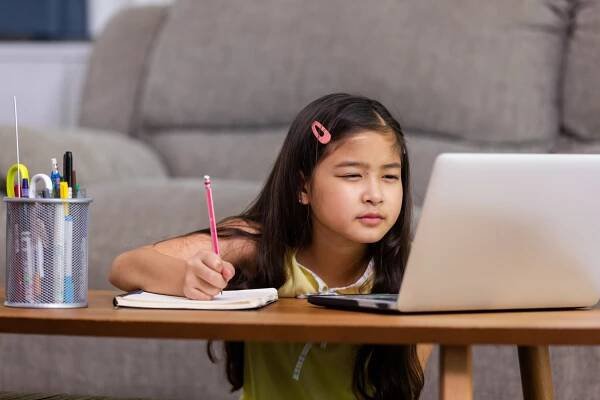 Child squinting at laptop screen.