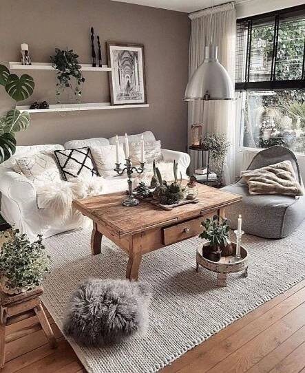 a living room filled with lots of furniture and plants on top of a wooden table