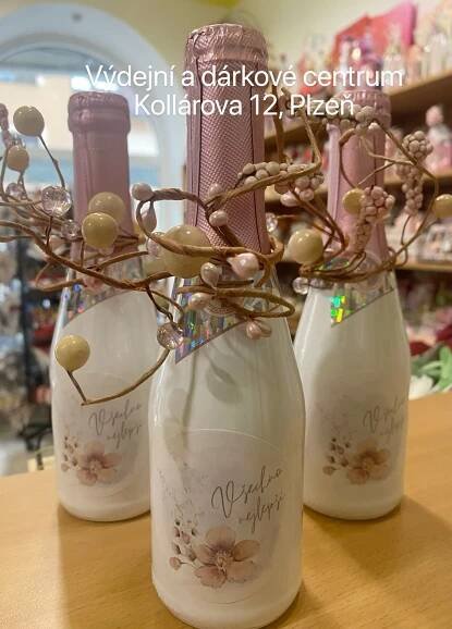 three vases with flowers in them sitting on a table next to other bottles and items