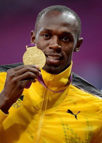 Bývalý sprinter Usain Bolt se zlatou olympijskou medailí.