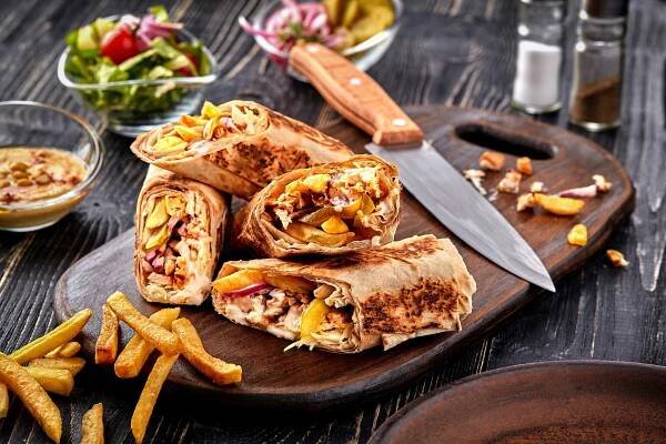 Kuřecí Shawarma roll v pita s čerstvou zeleninou, omáčkou a hranolky na dřevěné pozadí. Selektivní fokus — Stock obrázek