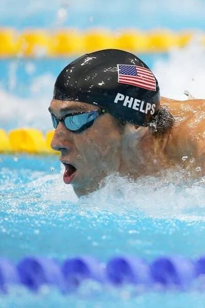a man swimming in a pool with an american flag on his cap and goggles