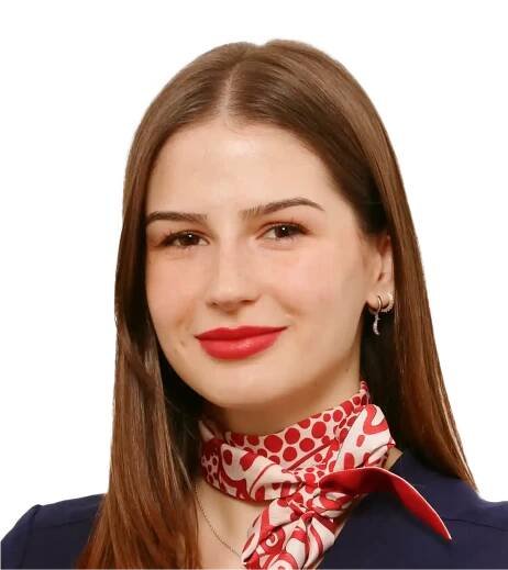 Porträt von Alexa Mihai aus dem Patient Service Team, mit braunem Haar, roten Lippen und einem rot-gemusterten Halstuch, lächelt dezent.