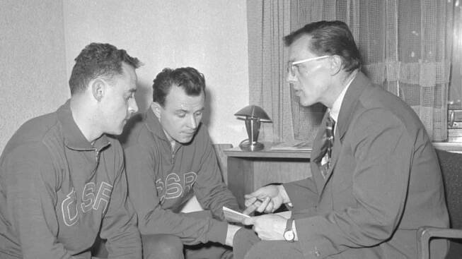 František Tikal s parťákem z obranného páru Karlem Gutem naslouchají při MS 1959 radám trenéra Vlastimila Sýkory.