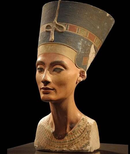 Portrait bust of Queen Nefertiti with her distinctive blue crown, showcasing her regal features and timeless beauty, on display at the Neues Museum in Berlin.