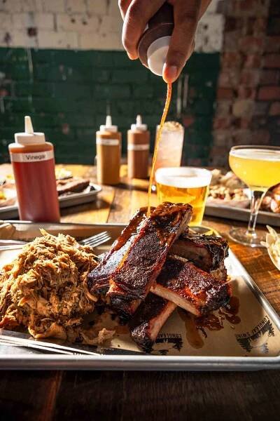 Shot of man putting vinegary sauce on barbecue