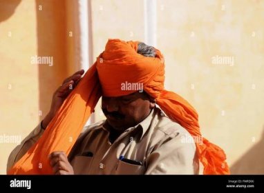 Tourists visiting the Meherangarh Fort near Jodhpur can watch a demonstration of how to put on a turban. Stock Photo
