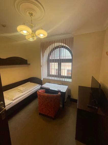 a room with a bed and a table and a window at Hotel Bravo in Česká Třebová
