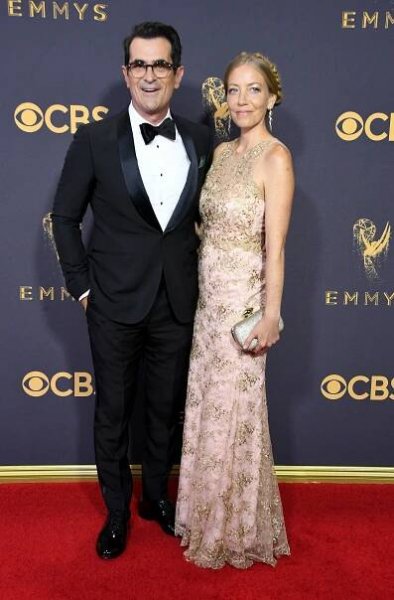 Ty Burrell in a tuxedo and his wife, Holly Burrell, in a floral dress.