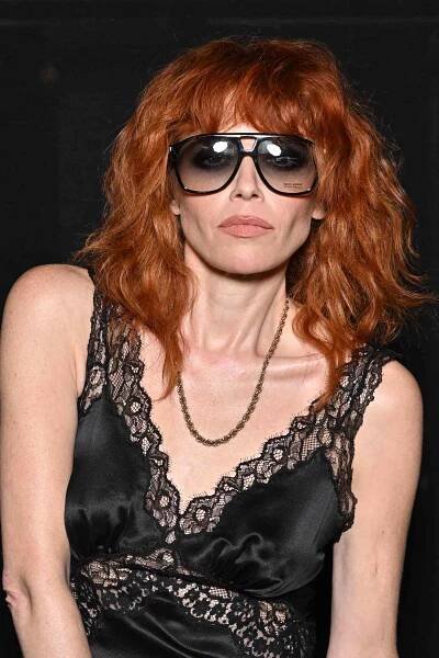 Natasha Lyonne with a red, shag hair cut while wearing sunglasses and a black lace dress