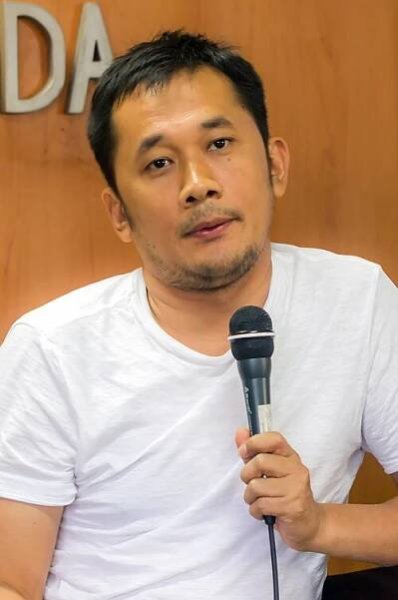 A man in a white shirt looking forward