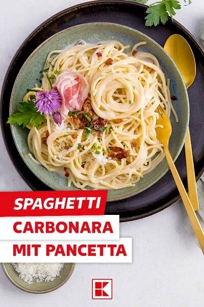 spaghetti carbonara mit pancetta on a plate with spoons