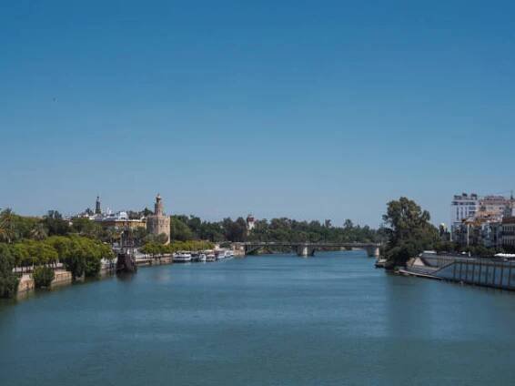 pohled na město sevilla z řeky guadalquivir s torre del oro (zlatá věž) a severní věž náměstí españa (španělské náměstí) v pozadí - triana - stock snímky, obrázky a fotky