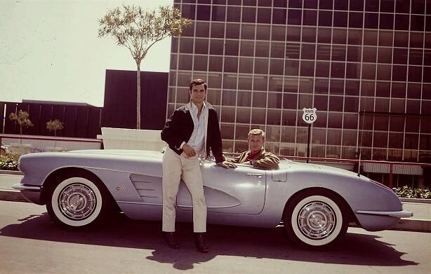 American actors George Maharis (standing) (as Buz Murdock) and Martin Milner (as Tod Stiles) pose with their blue Corvet from the television show 'Route 66,' 1960